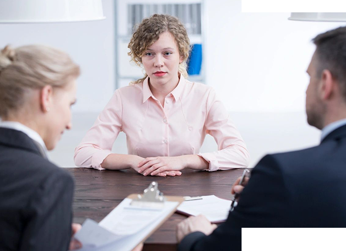 A woman sitting at a table with two other people.