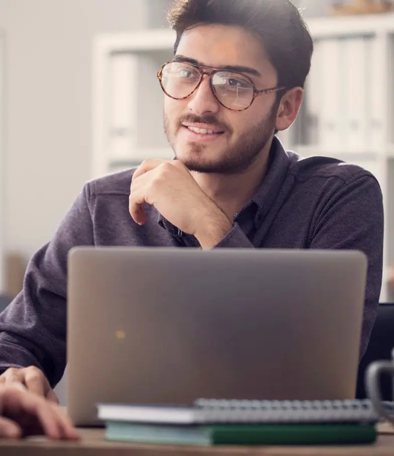 A man sitting at a table with his laptop.